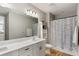 Clean bathroom design with tile floors, shower with curtain, and large vanity at 11435 Apple Tree Cir, Bradenton, FL 34211
