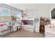 Bright bedroom with a white bunk bed, desk, and playful decor, illuminated by a stylish pendant light at 11435 Apple Tree Cir, Bradenton, FL 34211