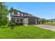 Charming two-story home featuring a three-car garage, lush lawn, and beautiful landscaping for enhanced curb appeal at 11435 Apple Tree Cir, Bradenton, FL 34211