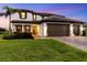 Charming two-story home with a lush green lawn and a three car garage at 11435 Apple Tree Cir, Bradenton, FL 34211