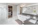 Main bathroom with dual sinks, glass shower, and access to walk-in closet at 11435 Apple Tree Cir, Bradenton, FL 34211