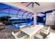 Covered patio with ample seating, TV, and view of a pool and lake at 11435 Apple Tree Cir, Bradenton, FL 34211