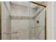 Tiled shower enclosure featuring glass doors, gold trim, and stylish fixtures offers a luxurious bathing experience at 1212 Benjamin Franklin Dr # 708, Sarasota, FL 34236