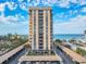 Exterior view of tall condo building with covered parking and ocean view at 1212 Benjamin Franklin Dr # 708, Sarasota, FL 34236