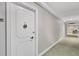 Hallway view with white condo door with seashell decoration on the front at 1212 Benjamin Franklin Dr # 708, Sarasota, FL 34236