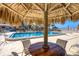 Relaxing pool area with tiki umbrellas and comfortable seating for residents and guests to enjoy under the Florida sun at 1212 Benjamin Franklin Dr # 708, Sarasota, FL 34236