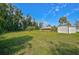 Spacious, fenced backyard with a large shed, mature trees and green grass at 12305 Harland St, North Port, FL 34287
