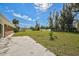 Expansive backyard with a concrete patio, lush green grass, and mature trees for privacy at 12305 Harland St, North Port, FL 34287