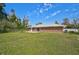 Lovely backyard featuring a well-manicured lawn, privacy fence, and a brick home with metal roof at 12305 Harland St, North Port, FL 34287