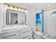 Modern bathroom with double vanity, gold fixtures, tiled shower, and beach themed shower curtain at 12305 Harland St, North Port, FL 34287