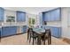 Renovated kitchen showcasing bright blue cabinetry, stainless steel appliances, and a dining area with modern decor at 12305 Harland St, North Port, FL 34287