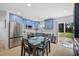 Modern kitchen features stainless steel appliances, blue cabinets, and a dining area with a sliding glass door at 12305 Harland St, North Port, FL 34287