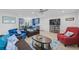 Spacious living room with modern furniture, a ceiling fan, and seamless access to a beautifully designed kitchen at 12305 Harland St, North Port, FL 34287