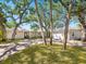 Inviting single-story home with well-manicured lawn and brick driveway, complemented by mature trees at 1248 Northport Dr, Sarasota, FL 34242