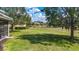 Expansive backyard with lush green lawn, mature trees, and serene pond views at 12628 Daisy Pl, Bradenton, FL 34212
