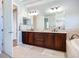 Bathroom featuring double vanity, ample cabinet space, soaking tub and walk-in shower at 12628 Daisy Pl, Bradenton, FL 34212