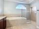 Bathroom with soaking tub and walk-in shower enclosed in clear glass at 12628 Daisy Pl, Bradenton, FL 34212