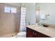 Bathroom featuring walk-in shower with tasteful neutral tiling, vanity, and modern fixtures at 12628 Daisy Pl, Bradenton, FL 34212