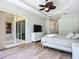 Bedroom featuring ceiling fan, dresser with tv and slider doors to another room at 12628 Daisy Pl, Bradenton, FL 34212