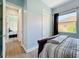 Bright bedroom with light blue walls, laminate floors, closet, and natural light from window at 12628 Daisy Pl, Bradenton, FL 34212