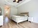 Bright bedroom featuring a ceiling fan, a comfortable bed, and wood flooring at 12628 Daisy Pl, Bradenton, FL 34212