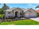 Charming one-story home features a well-manicured lawn, beautiful landscaping, and a three-car garage at 12628 Daisy Pl, Bradenton, FL 34212
