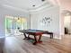 Bright game room with a pool table, modern lighting, and a screened lanai at 12628 Daisy Pl, Bradenton, FL 34212