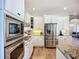 Well-appointed kitchen with stainless steel appliances and sleek white cabinetry, view to living room at 12628 Daisy Pl, Bradenton, FL 34212