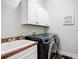Bright laundry room with white cabinets, sink, and front load washer and dryer at 12628 Daisy Pl, Bradenton, FL 34212