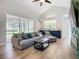Bright living room with vaulted ceilings, large windows offering natural light, and a stylish blue accent cabinet at 12628 Daisy Pl, Bradenton, FL 34212