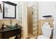 Bright bathroom features a glass vessel sink, tiled shower with glass block, and modern fixtures at 1311 Cypress Ave, Venice, FL 34285