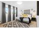 Bedroom with a large window, gray curtains, modern decor, and neutral tones at 1311 Cypress Ave, Venice, FL 34285