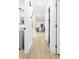 Bright hallway with light wood flooring, leading to a dining area and rooms with closet space at 1311 Cypress Ave, Venice, FL 34285
