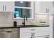 Close-up of the kitchen sink area with a modern faucet, granite countertops, and white cabinets at 1311 Cypress Ave, Venice, FL 34285