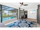 Cozy living room with a ceiling fan, pool view, and stylish blue rug at 1311 Cypress Ave, Venice, FL 34285