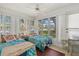 Bright sunroom with twin beds surrounded by multiple windows offering scenic views and natural light at 1343 Glendale W Cir # 216, Sarasota, FL 34232