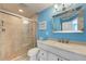 Bathroom featuring walk-in shower with glass door, neutral tiles, and vanity with sink and mirror at 1500 Cove Ii Pl # 524, Sarasota, FL 34242