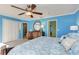 Bright bedroom features blue walls, ensuite bathroom, dresser with round mirror, and closet at 1500 Cove Ii Pl # 524, Sarasota, FL 34242