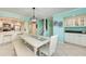 Open-concept dining space leads to the kitchen, featuring white cabinetry, stainless appliances, and ample natural light at 1500 Cove Ii Pl # 524, Sarasota, FL 34242
