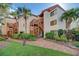 Beautiful condo building with lush landscaping and exterior stairs to upper units at 1500 Cove Ii Pl # 524, Sarasota, FL 34242