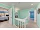 Bright hallway with staircase leads to the primary bedroom with balcony access and a sunburst mirror at 1500 Cove Ii Pl # 524, Sarasota, FL 34242