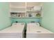 Laundry room features washer, dryer, and ample storage shelves at 1500 Cove Ii Pl # 524, Sarasota, FL 34242