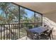 Screened in patio with table and chairs overlooking the backyard at 1500 Cove Ii Pl # 524, Sarasota, FL 34242