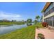 Waterfront backyard view featuring a well-maintained lawn and a tranquil canal at 1759 Lake Pl # 1759-B, Venice, FL 34293