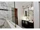 Elegant bathroom features marble walls, vanity with dark wood cabinet, and a glass-enclosed shower and closet at 17817 Woodland Ct, Punta Gorda, FL 33982