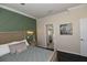 Cozy bedroom features a decorative green accent wall, wood floors, and a view into the ensuite bathroom at 17817 Woodland Ct, Punta Gorda, FL 33982