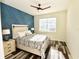 Bedroom features a patterned accent wall, dark wood floors, and natural light from the large window at 17817 Woodland Ct, Punta Gorda, FL 33982