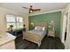 Bedroom boasts modern style with a green accent wall, ceiling fan and a picturesque window view at 17817 Woodland Ct, Punta Gorda, FL 33982