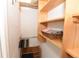 Walk-in closet with wood shelving, hanging rods, and a basket of towels for optimal storage at 17817 Woodland Ct, Punta Gorda, FL 33982