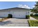 Attached two-car garage exterior showcasing a well maintained driveway and tidy landscaping at 17817 Woodland Ct, Punta Gorda, FL 33982